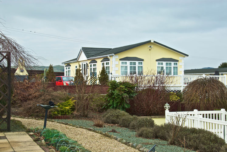 A yellow residential park home at Courthill
